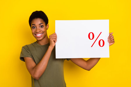 Photo of cheerful friendly person hold sale empty space list poster isolated on yellow color...