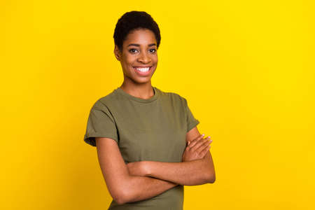 Photo of confident cheerful folded arms beaming smile look camera isolated on yellow color backgroundの写真素材
