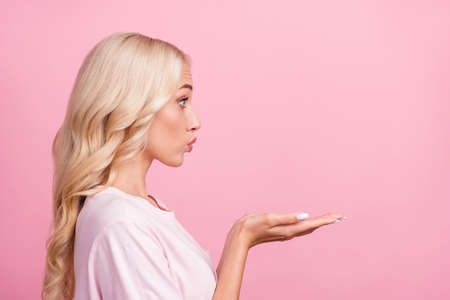 Profile photo of sweet millennial blond lady blow kiss wear t-shirt isolated on pink color backgroundの写真素材