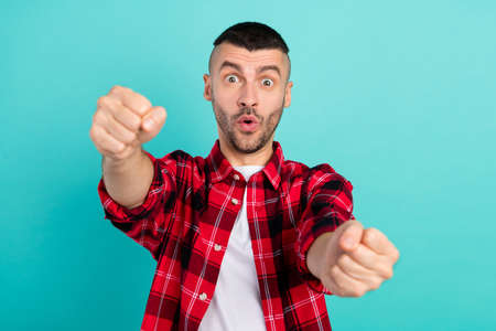 Photo of young impressed brunet guy wear red shirt isolated on teal color backgroundの写真素材