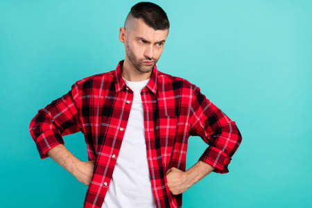 Photo of millennial mad brunet guy look empty space wear red shirt isolated on teal color backgroundの写真素材