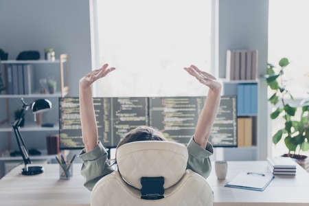 Rear behind portrait of hardware expert sitting chair raise stretch arms two screens office room...