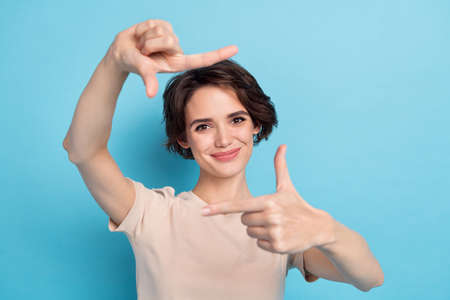Photo of young positive cheery girl take picture of you catch memorable moment isolated on blue...