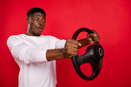 Photo of funny shocked guy dressed white shirt automobile driver looking empty space isolated red color backgroundの写真素材