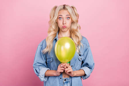 Photo of young girl unhappy moody pouted cheeks bad surprise birthday party balloons isolated over pink color backgroundの写真素材