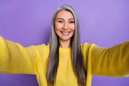 Photo of adorable cute retired woman wear sweater tacking selfie isolated violet color backgroundの写真素材