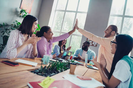 Photo of positive cheerful businessman businesswoman applauding celebrating winning tender indoors...