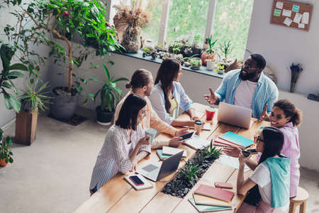 Photo of positive pretty businesspeople creating new startup discussing indoors workstation workshop restroomの写真素材
