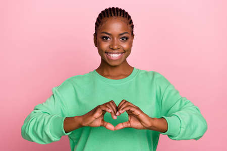 Portrait of cheerful pretty girl hands demonstrate heart symbol isolated on pink color background