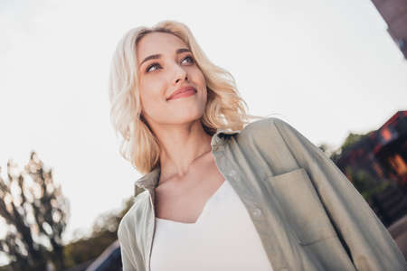 Portrait of attractive dreamy calm wavy haired girl strolling enjoying spending spare time in...