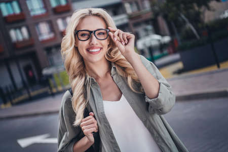Photo of lovely satisfied person arm touch eyewear have good mood spend pastime walk outsideの写真素材
