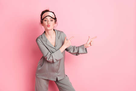 Photo of young girl pouted lips point fingers empty space ad advice choice isolated over pink color backgroundの写真素材