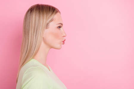 Profile photo of romantic lady look empty space blow air kiss wear green t-shirt isolated on pink backgroundの写真素材