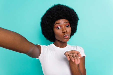 Photo of sweet flirty dark skin lady wear casual clothes tacking selfie sending you arm kiss...