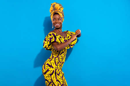 Photo of happy excited cheerful smiling african woman look copyspace dancing isolated on blue color...