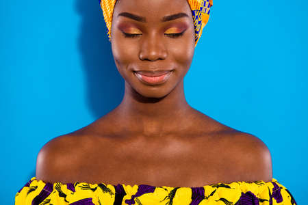 Photo of charming positive dark skin girl closed eyes smile enjoy free time isolated on blue color backgroundの写真素材