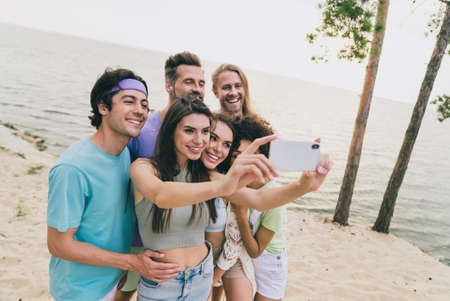 Photo of pretty attractive best buddies walking embracing recording self video enjoying summer time outdoors ocean seasideの写真素材
