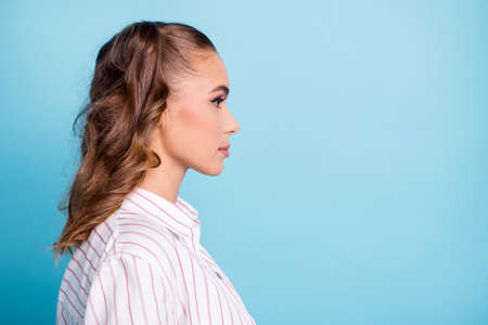 Profile side view portrait of attractive confident brown-haired girl copy empty place space isolated over bright blue color backgroundの写真素材