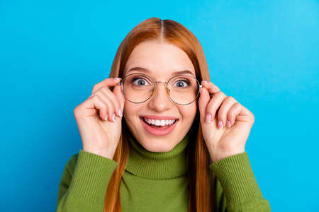 Portrait of impressed positive lady hands touch glasses toothy smile look camera isolated on blue...