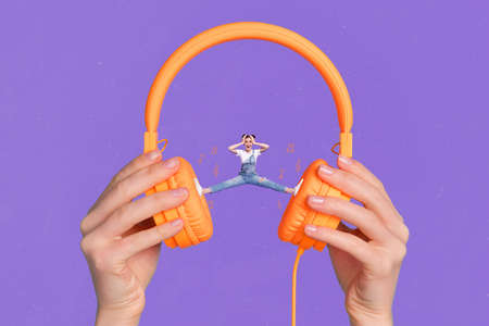 Creative collage picture of huge hands hold headphones mini girl split legs stand between earphones isolated on violet backgroundの写真素材