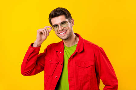 Photo of funny millennial brunet guy wear red shirt glasses isolated on yellow color backgroundの写真素材