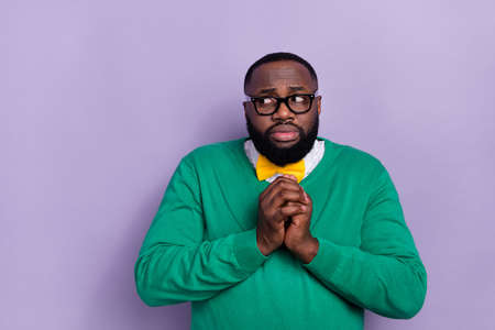 Photo of terrified young man hold arms look interested empty space isolated on violet color backgroundの写真素材
