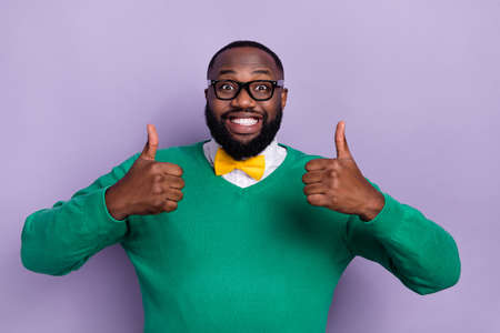 Photo of cheerful friendly person two hands fingers demonstrate thumb up isolated on violet color backgroundの写真素材