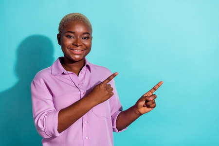 Photo of positive pretty person direct fingers empty space offer promotion isolated on turquoise color backgroundの写真素材