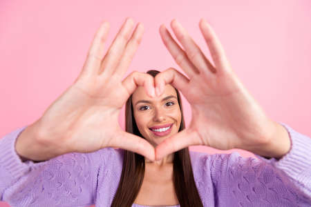 Photo of charming shiny young woman dressed purple clothes showing fingers heart cover face smiling...