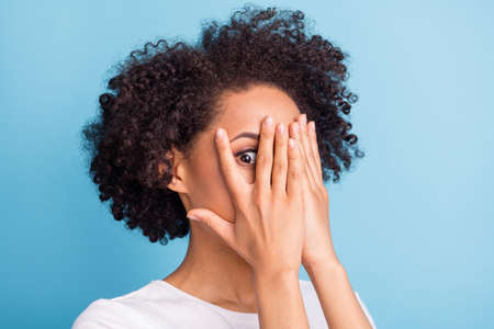 Portrait of young scared afraid frightened african girl cover face with hands stressed isolated on...