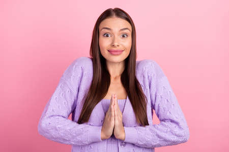 Photo of hopeful lady hold palms together ask request wear violet cardigan isolated pink color...