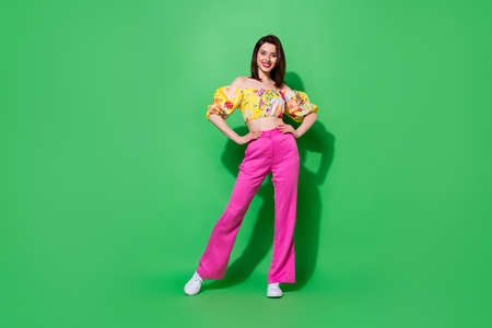 Full size photo of gorgeous positive lady put hands waist posing isolated on green color background