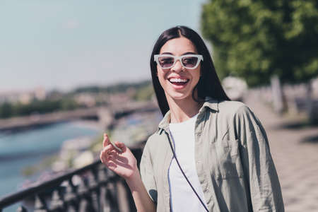 Photo of cute lovely good mood lady laughing have fun enjoy city walk sightseeing tour outside