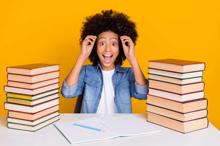 Portrait of attractive trendy cheery amazed teen girl doing home work good mood isolated over bright...