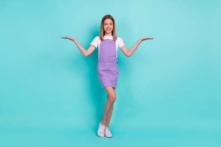 Full size portrait of charming cute girl arms palms hold demonstrate empty space scales isolated on...