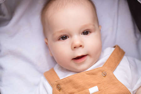 Photo of sweet charming small daughter wear casual outfit lying baby carriage smiling outside garden