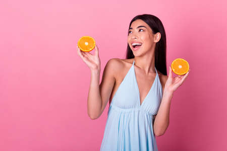 Photo of positive crazy cute lady hold mandarin look empty space isolated on pastel color backgroundの写真素材