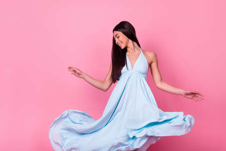 Photo of cute lovely lady moving around skirt outfit flying air isolated pastel color backgroundの写真素材