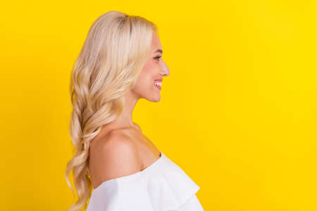 Profile side view portrait of gorgeous cheerful content wavy-haired girl copy space isolated over vibrant yellow color backgroundの写真素材