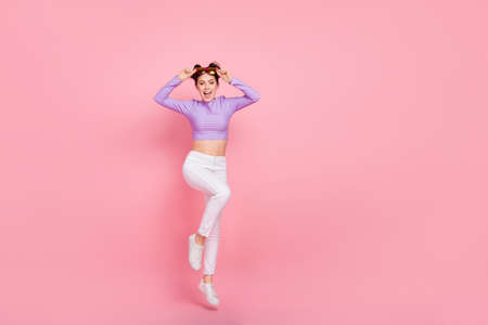 Full length body size view of attractive cheery thin girl jumping having fun isolated over pink...