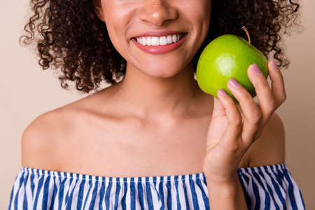 Photo of gorgeous cheerful lady wear striped outfit enjoying juicy fruit smiling isolated beige color backgroundの写真素材