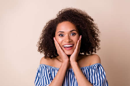 Photo of astonished lady arm touch cheekbones unbelievable isolated on beige color backgroundの写真素材