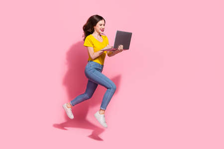 Full body profile photo of sweet young brunette lady run with laptop wear t-shirt jeans shoes...