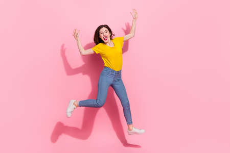 Full size photo of hooray millennial brunette lady jump wear t-shirt jeans shoes isolated on pink...