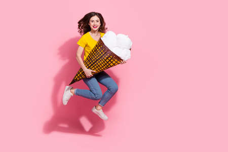 Full length photo of funky young brunette lady jump with pinata wear t-shirt jeans footwear isolated...