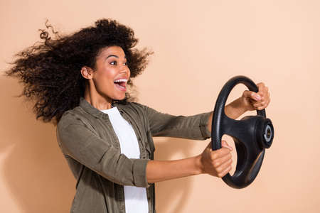 Profile side photo of young african girl drive auto transport look empty space journey isolated over beige color backgroundの写真素材