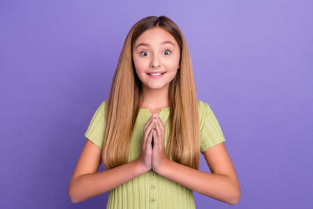 Portrait of positive cute girl arms palms touch pleading toothy smile isolated on purple color backgroundの写真素材
