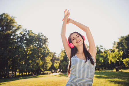 Portrait of attractive cheerful dreamy girl enjoying listening stereo hit single sound on fresh air pastime outdoorsの写真素材