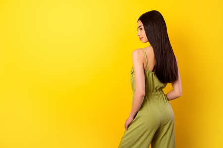 Profile portrait of lovely young vietnamese girl look empty space isolated on yellow color backgroundの写真素材
