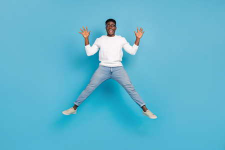 Full body portrait of amazed overjoyed person have good mood jumping isolated on blue color...